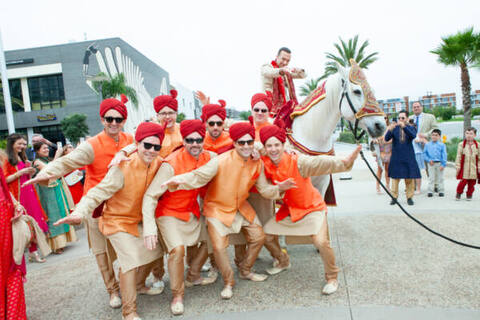 Three women in colorful outfits sitting on a bed of flowers.