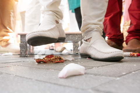 Three women in colorful outfits sitting on a bed of flowers.