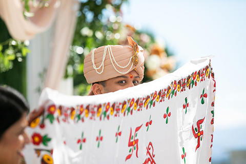 Three women in colorful outfits sitting on a bed of flowers.
