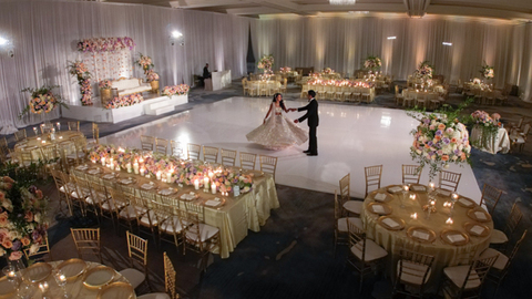 Three women in colorful outfits sitting on a bed of flowers.
