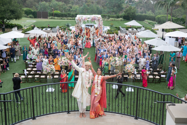A couple poses for a picture in front of an audience.