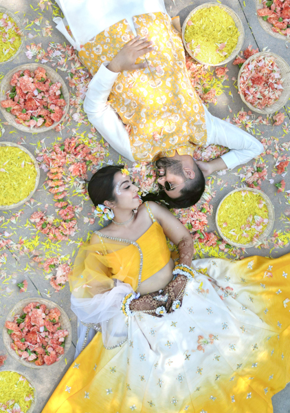 A man and woman laying on the ground with food.