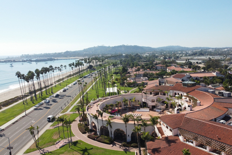Three women in colorful outfits sitting on a bed of flowers.