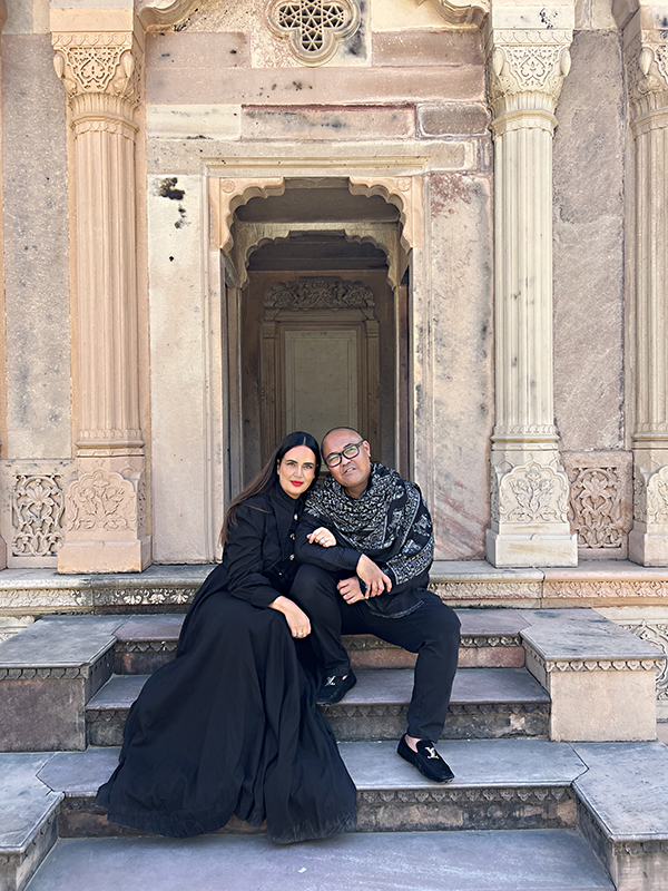 A man and woman sitting on steps in front of a building.